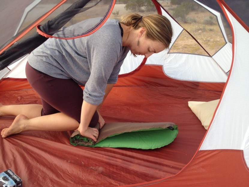 sleeping pad womens - the author trying to roll a self-inflating pad back up to fit in...