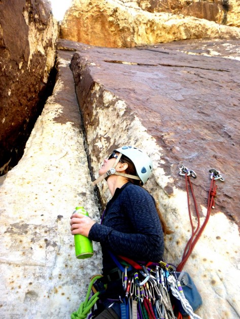 rei space dye zip-t - amber checks out the next pitch on a multi-pitch climb in red rocks...