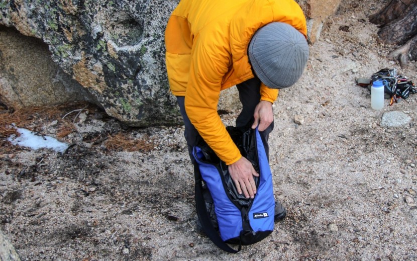 stuffing the rolled tarp into the bag's only cavity.