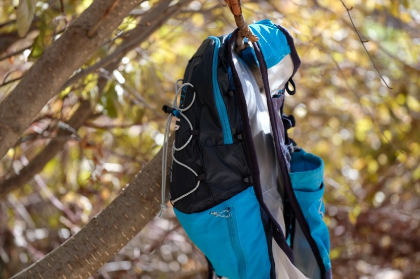 ultimate direction ultra vest 4.0 - the lower blue zippered pouch is stretchy enough to accomodate a...