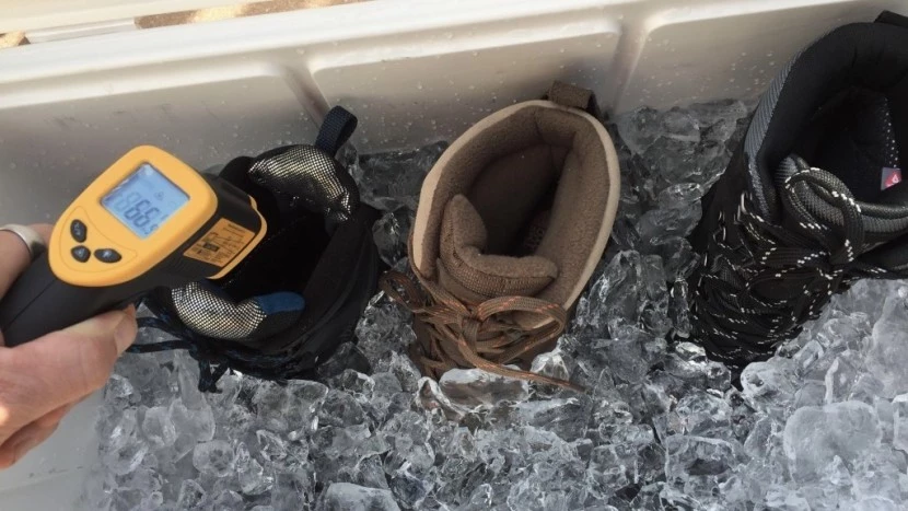 Professional winter boot testing in snowy conditions showing temperature measurement