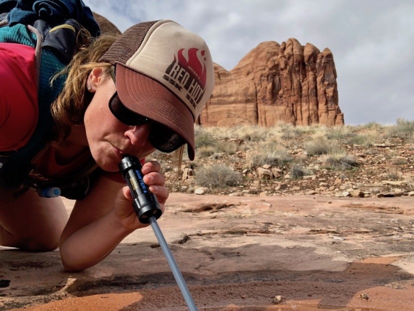sawyer mini - grabbing water from a shallow puddle on a trail run in the desert is...