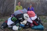 The authors of the our backpacking sleeping bag reviews with a pile...