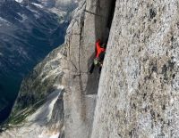 Climbing a wide fists and offwidth pitch high on the...