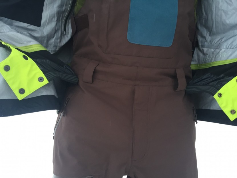 flylow gear baker bib - a closer look at how flylow pants button to the powder skirt of a...