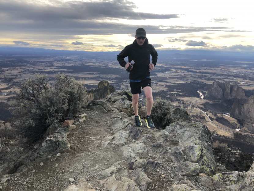 trail running shoes men - running along a rocky ridgeline high above smith rock state park in...