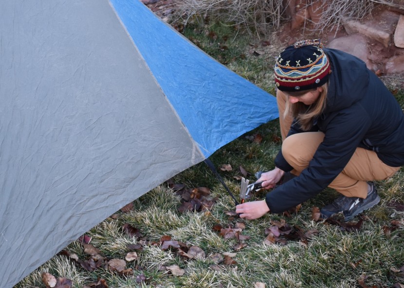 setting up a shelter using tester tent stakes in firm ground.