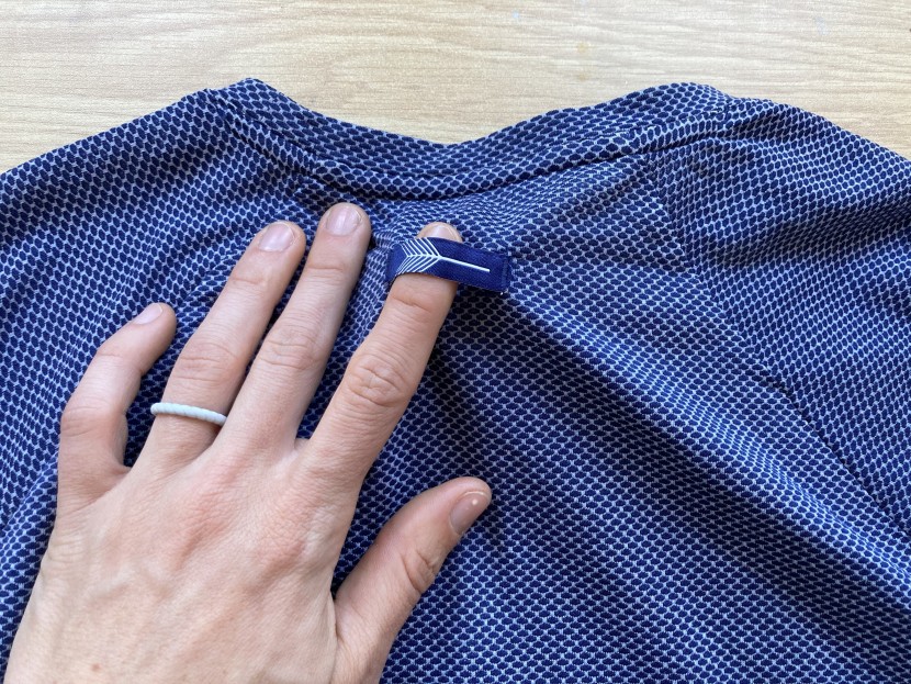 oiselle flyout short sleeve for women - a graphic tag on the back can double as a hanging loop as we see...