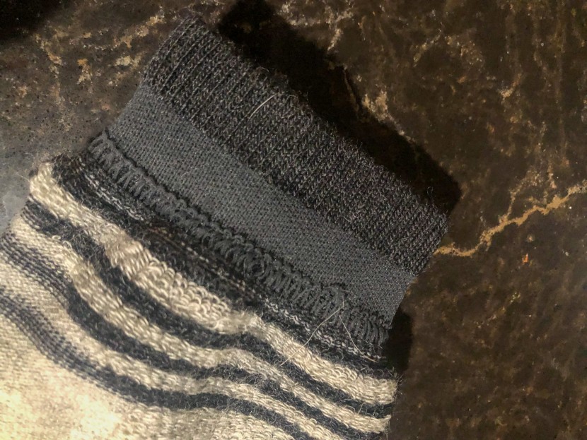 the band at the top of the sock does a fine job of holding the cuff...