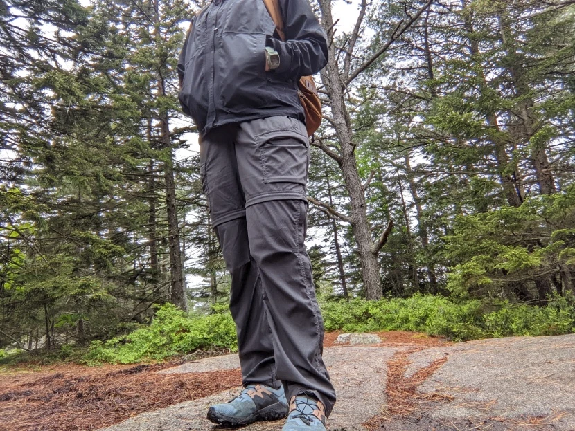 Woman testing waterproof rain pants in outdoor conditions