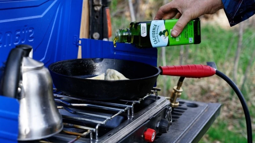 Camp stove and cooking equipment setup on camping table
