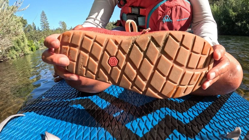 Water hiking shoes being tested on wet rocky terrain with excellent traction grip