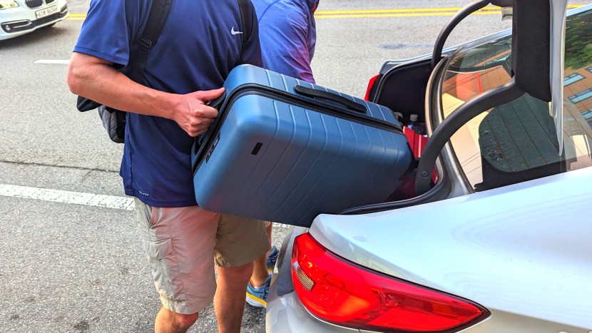 loading our away the carry-on into the back of a taxi in downtown...