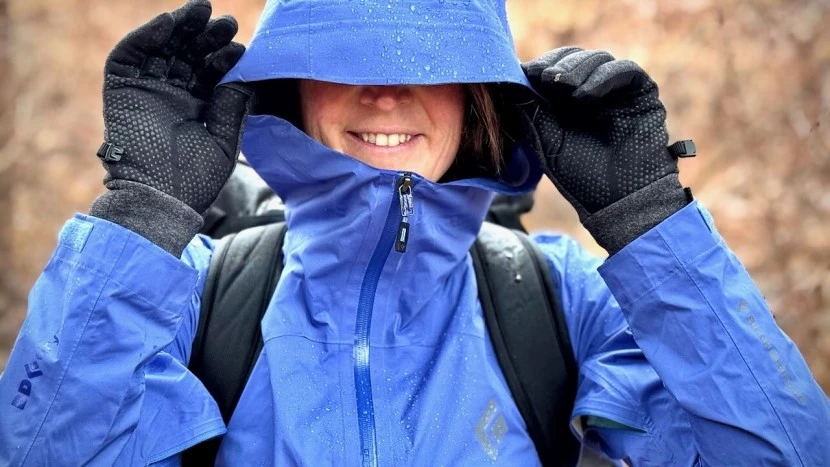 Outdoor enthusiast testing rain gear flexibility and movement during active use