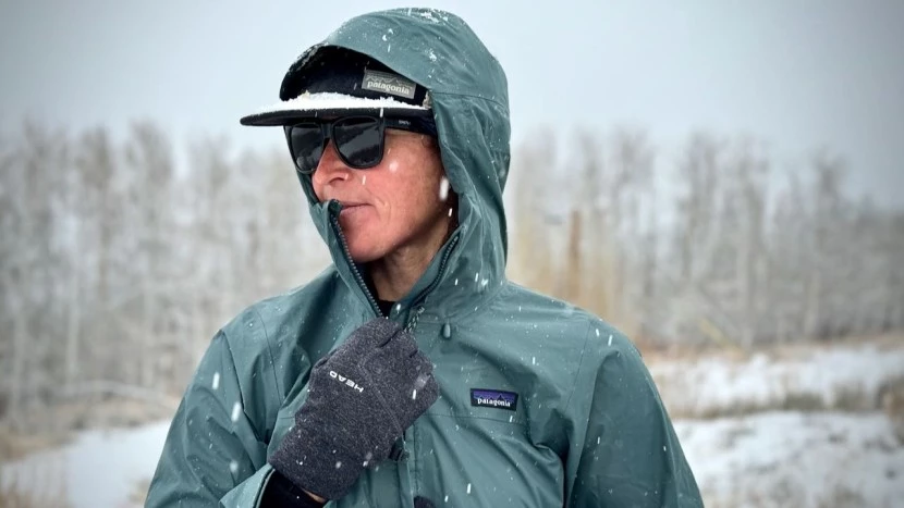 Person wearing waterproof rain jacket in heavy downpour demonstrating best waterproof rain gear performance