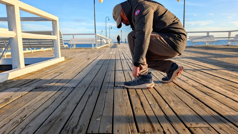 canada goose langford parka - stopping to tighten a lace while visiting a seaside pier near the...