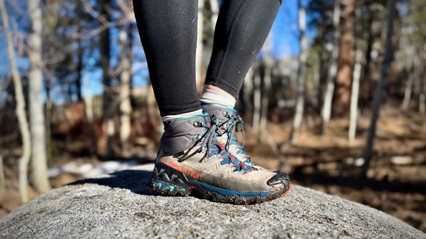 Hiker wearing high-cut 8 hiking boots traversing rocky mountain terrain