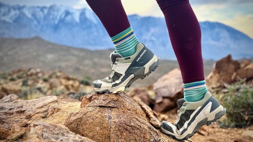 Hiker wearing wide hiking shoes on mountain trail with backpack