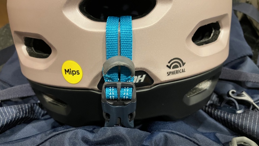 using the front stash pouch clip to secure a helmet.